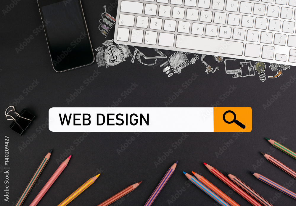 Wall mural web design concept. colorful pencils and a computer keyboard with a mobile phone on a black table.