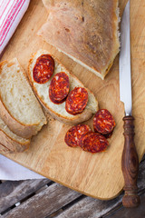 knife, fresh bread and sausage on the table