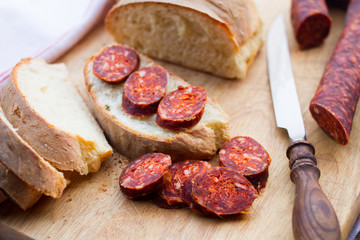 knife, fresh bread and sausage on the table