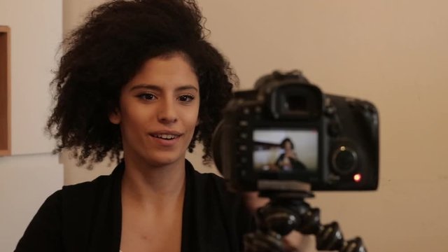 Smiling young female shooting self video