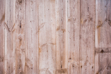 Closeup of texture of old weathered brown wooden fence with rusty nails. Horizontal color photo.