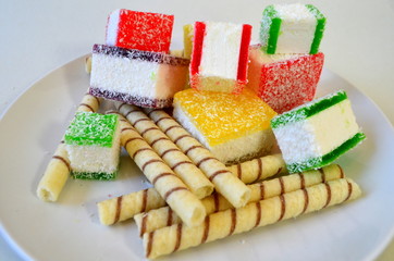 Разноцветный мармелад нарезанный кусочками на белой тарелке - вред сладкого 