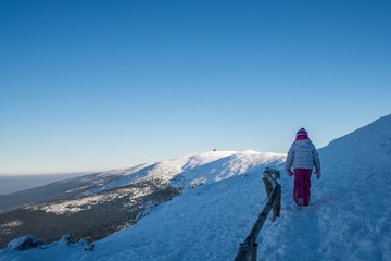 Fototapeta na wymiar Girl on a mountain trail in winter