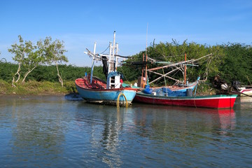 Two colorful traditional fishing boats on a river, Thailand