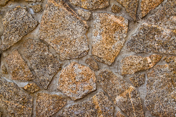The surface texture of a cement wall with a piece of rock.
