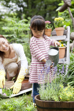 Girl watering on potted flower