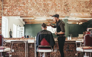 Crédence de cuisine en verre imprimé Salon de coiffure Hairstylist cutting hair of male customer