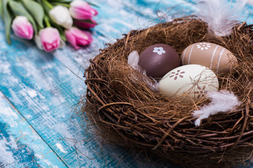 Obraz premium Happy Easter background, eggs, nest, tulips