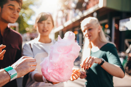 Three young people sharing cotton candyfloss