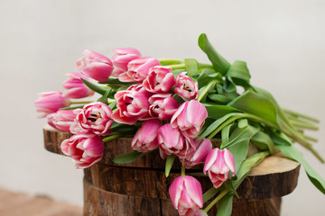 A large bouquet of pink tulips on wooden background. Springtime.
