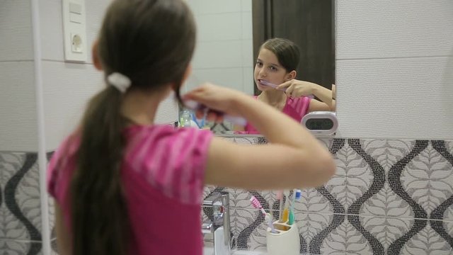 Girl brushing his teeth mirror