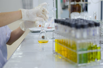 Scientist hand titration at laboratory, titrate chemical, titration with burette and erlenmeyer flask. erlenmeyer flask and test tube.