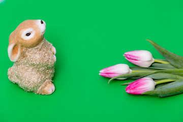 Easter background. bunny and tulips on a green background.