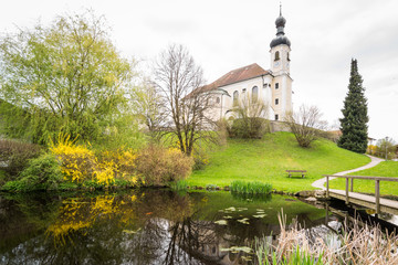 Fototapeta premium Kirche St Johannes in Breitbrunn am Chiemsee an einem Frühlingstag, Bayern in Deutschland