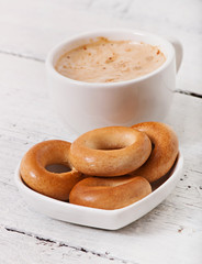 Cup of coffee and delicious baked cookies on old wooden background.