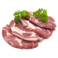 Raw pork neck chop meat with parsley herb leaves garnish isolated on white background cutout