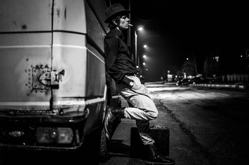 Cool young man with a cigarette at night black and white