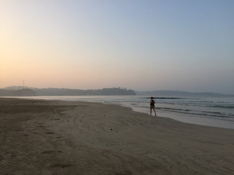 a young tourist is jogging during sunrise at Weligama bay, Sri Lanka