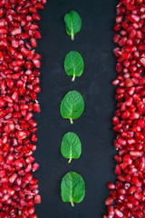 Pomegranate with mint on a black background