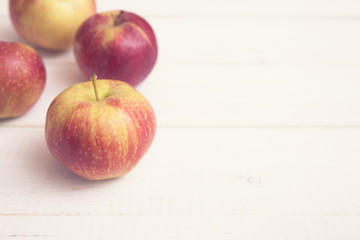 Red apples on a white wooden table
