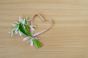 A bouquet of beautiful white snowdrops on wooden background