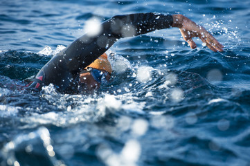 Unknown Swimmer at sea. - obrazy, fototapety, plakaty