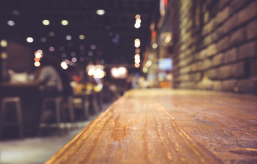 Wood bar (table) on cafe in dark night with people and light background/selective focus.For product...