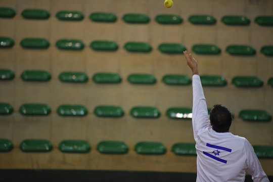 The tennis player is serving the ball 