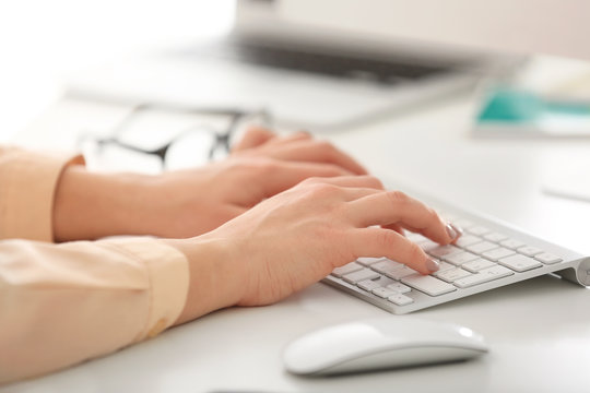Closeup view of female hands typing on keyboard