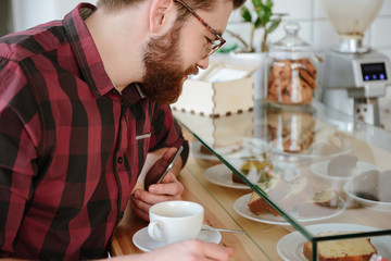 Cropped image of a handsome man choosing sweet pastry