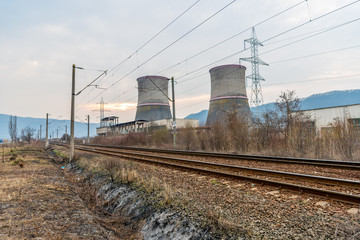 Fototapeta na wymiar Cooling towers of thermal power plant near the railway