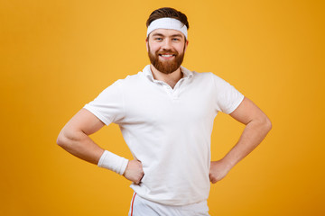 Happy sportsman with arms at hip