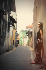 beautiful young woman standing near wall in the one of streets of Sri Lanka