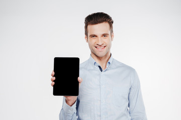 Young man showing blank tablet computer screen