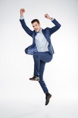 Full length portrait of business man jumping in studio