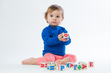 Little child playing with dices isolated on white background