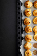 Baked profiteroles on tray ready for croquembouche. Top view. Copy space
