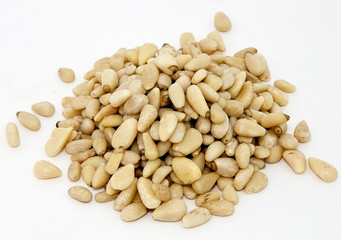 Mound of shelled pine nuts on white background.