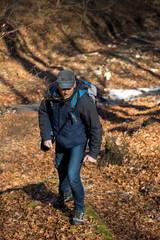Fototapeta na wymiar Mature man hiking in the forest in early spring