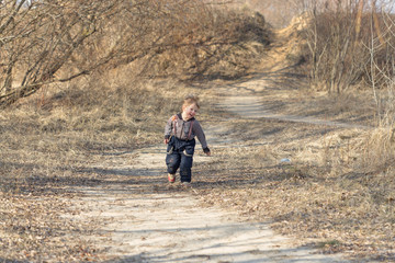 Running cheerful boy on nature in spring