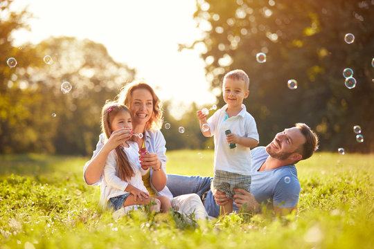 Family with children blow soap bubbles