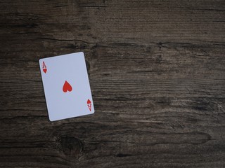 Casino play card Ace red heart on wooden vintage dark brown grunge texture on top able plan view with copy space