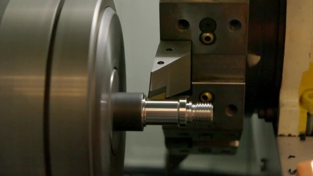 Action of turning lathe. Piece of metal spinning. Power and precision.