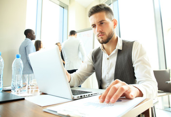 Obraz premium Handsome businessman working with laptop in office.