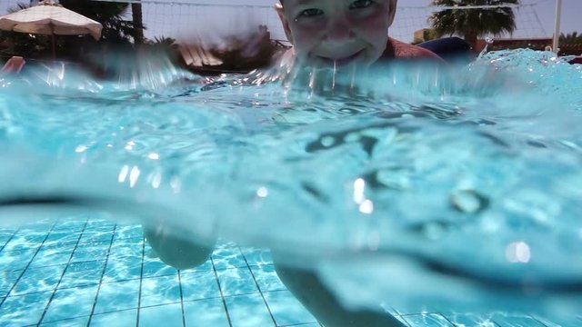 Little boy swim in pool, underwater shoot