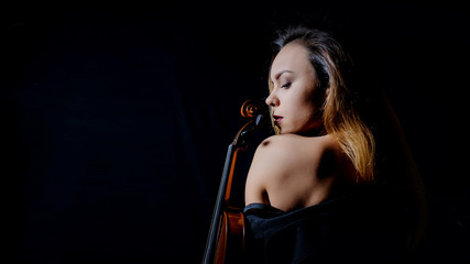 Obraz premium Beautiful young woman playing violin