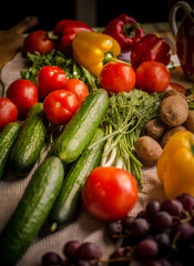 Various vegetables and fruits, bright colors, are on the kitchen table.
