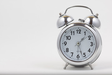 Nice old vintage chrome metal twin bell alarm clock on white background with copy space.	