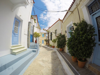 Fototapeta na wymiar POROS, GREECE - JUNE 08, 2016: photo of cozy beautiful street full of plants and colours in the sunny Greece
