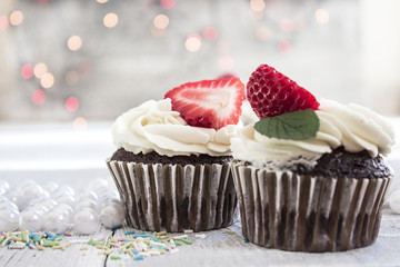 Chocolate cupcakes with white creme and strawberry on top in the white box